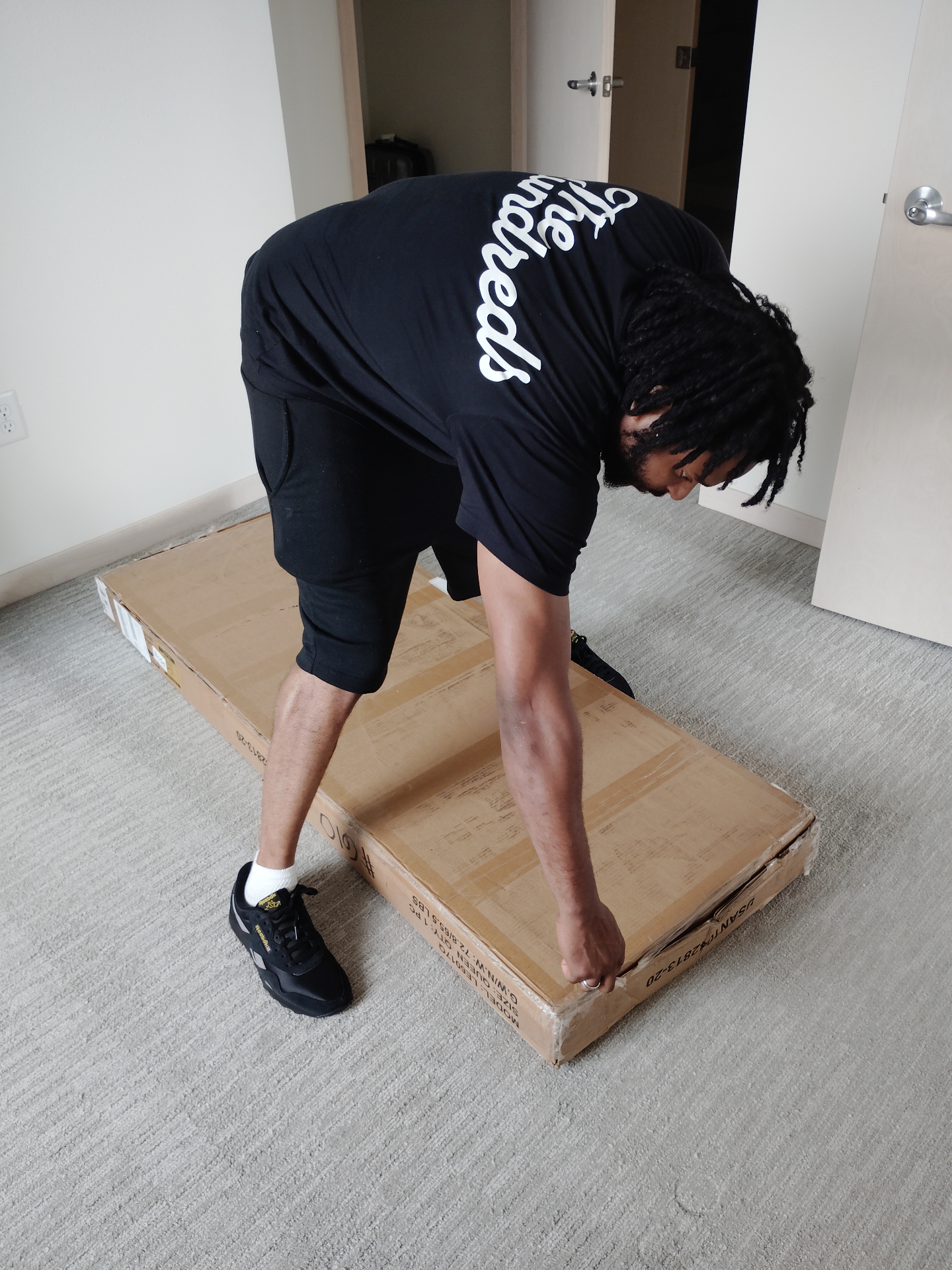 Piece by Piece assembler unboxing a queen bed frame in a Madison home